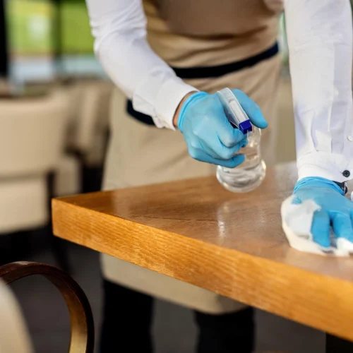 closeup-waiter-disinfecting-cafe-tables-after-work